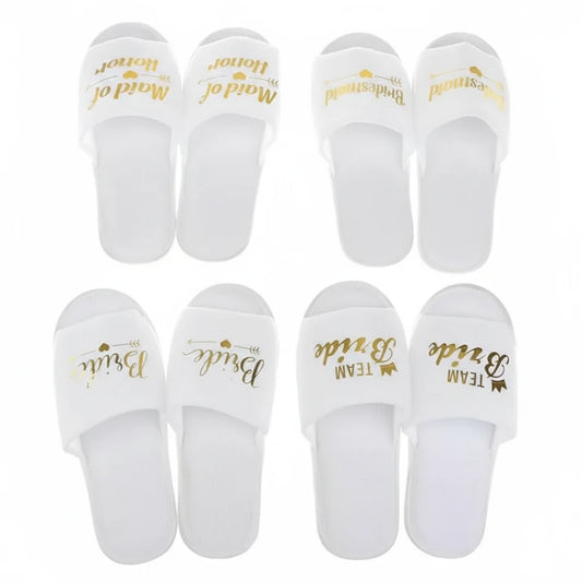 Set of white slippers with gold text on a white background