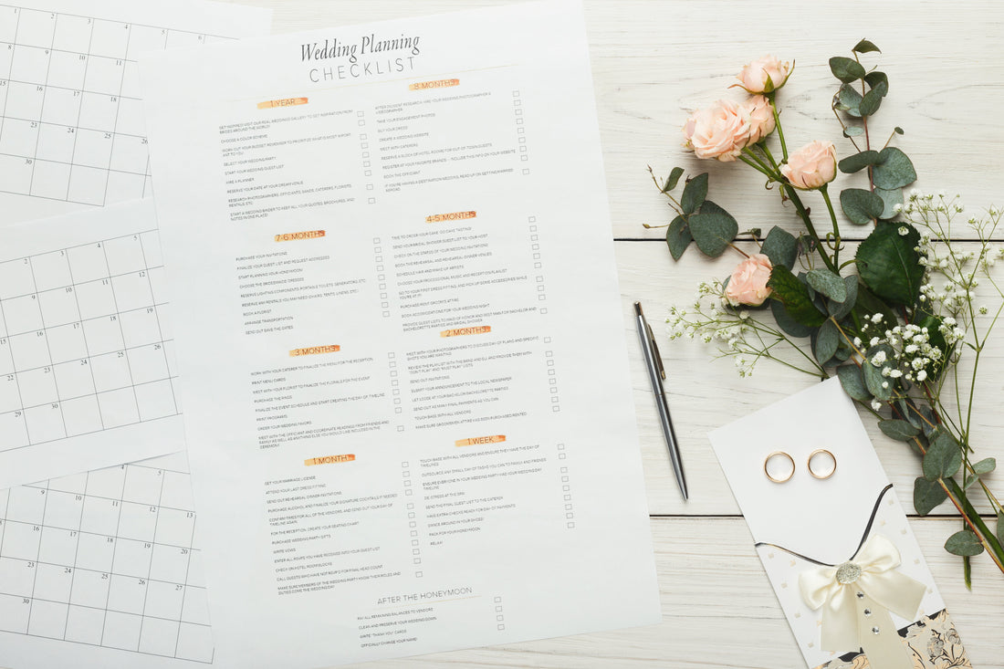 Wedding planning checklist with pen and flowers on the table.