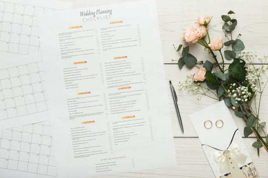 Wedding planning checklist with pen and flowers on the table.