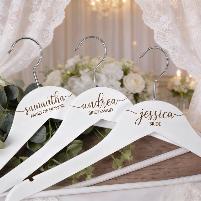 Three white hangers with personalized names on a decorative background