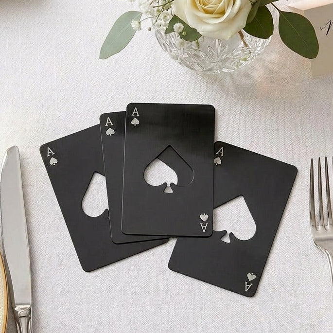 Black playing card favours on a table setting with flowers and name cards.