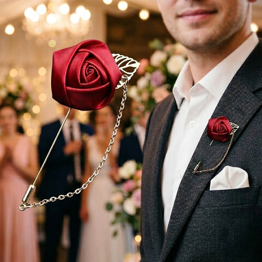 Man in a suit with a red rose lapel pin at an event.