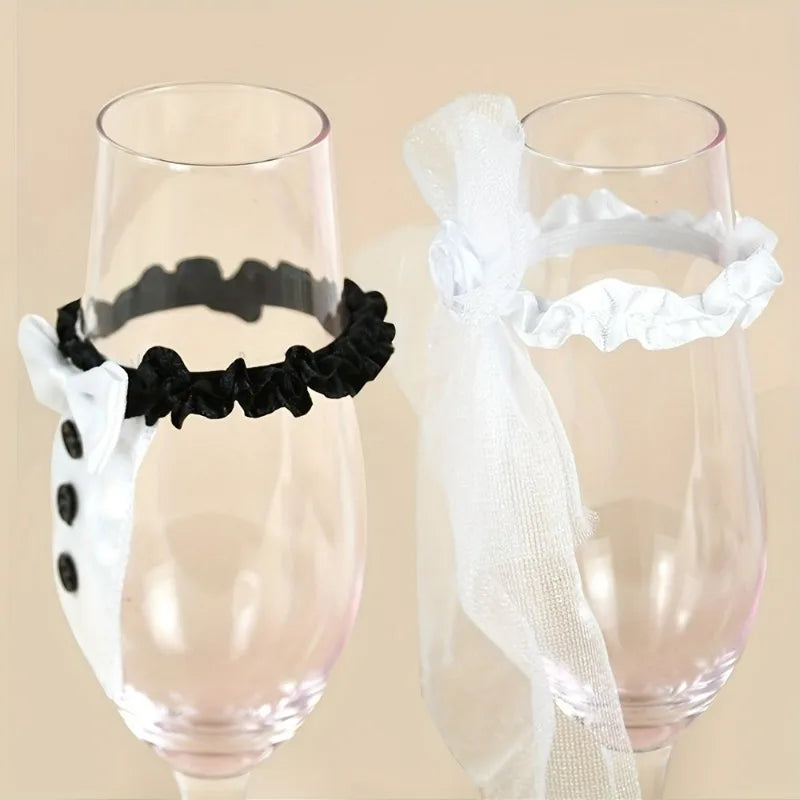 Two glasses with decorative ribbons, one black and one white, on a beige background.