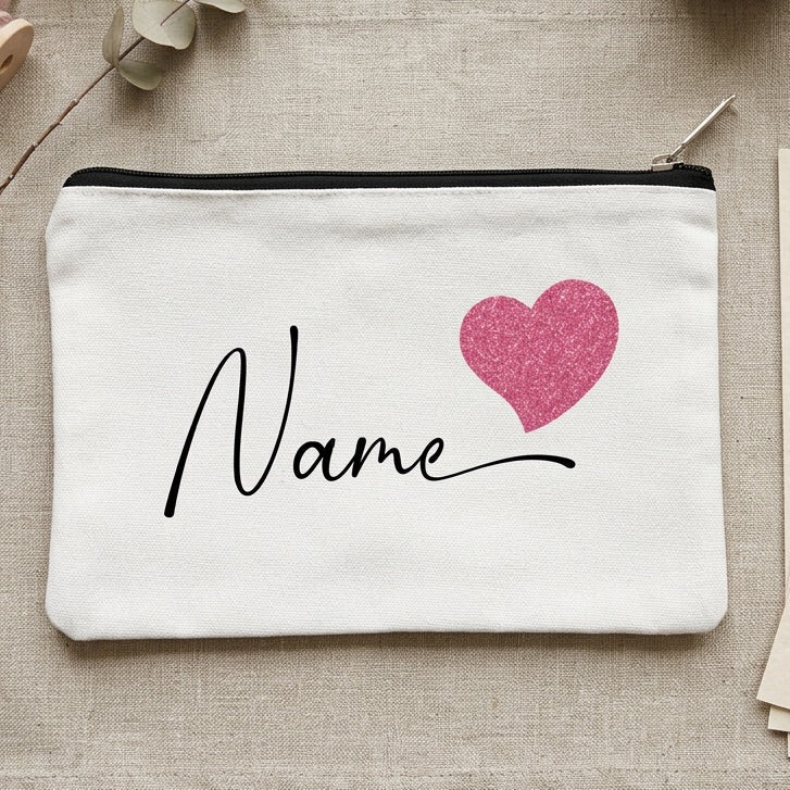 White pouch with pink heart and 'Name' text on a textured surface with decorative items.