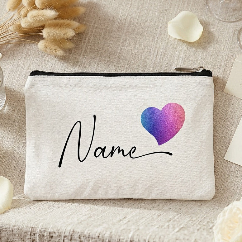 White make up bag with a colorful heart and 'Name' text on a decorative surface with flowers and cards.