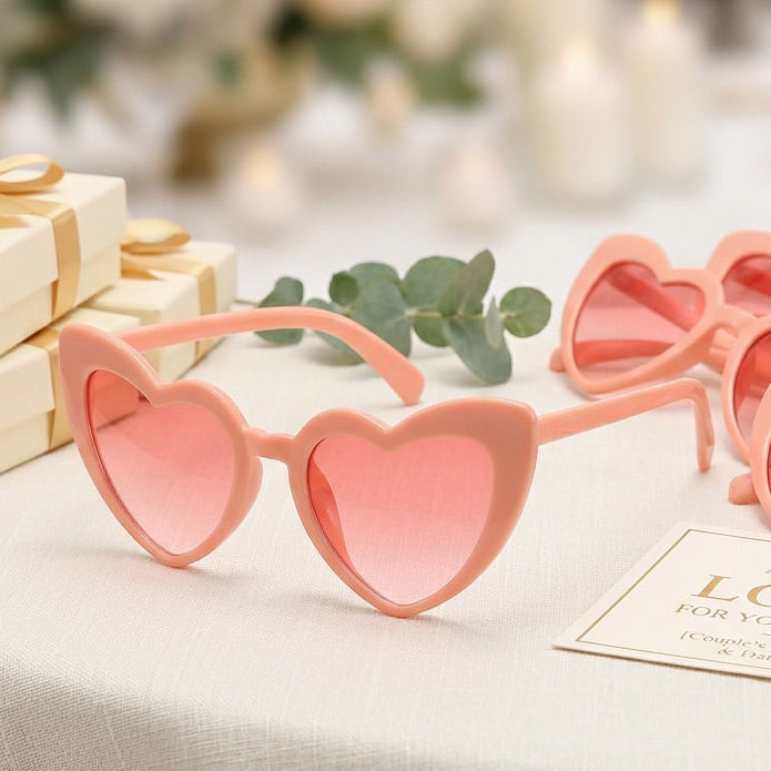 Heart-shaped pink sunglasses on a table with decorative elements