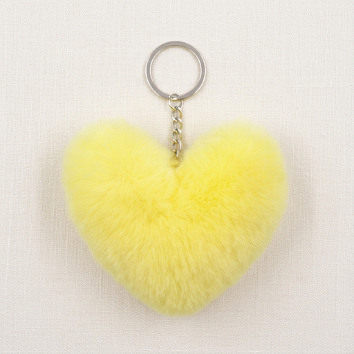 Yellow heart-shaped fluffy keychain on a white background