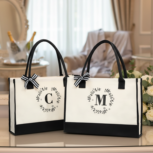 Two tote bags with monograms 'C' and 'M' on a white surface.