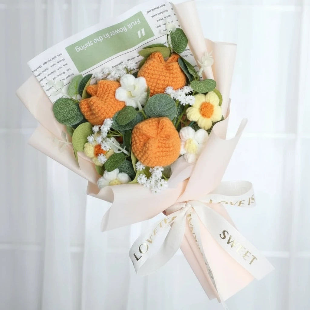 Bouquet of knitted orange flowers and green leaves with a white background