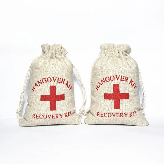 White cotton wedding favour bag with red ‘Hangover Recovery Kit’ text and red cross design