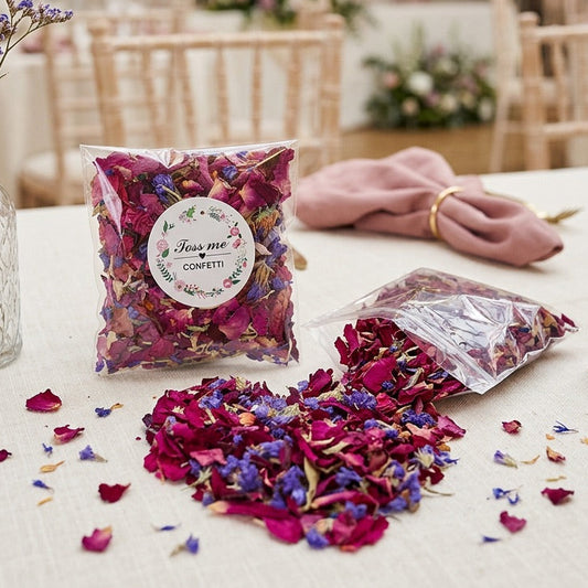 Colorful confetti packets and a vase with flowers on a table in a decorated room.