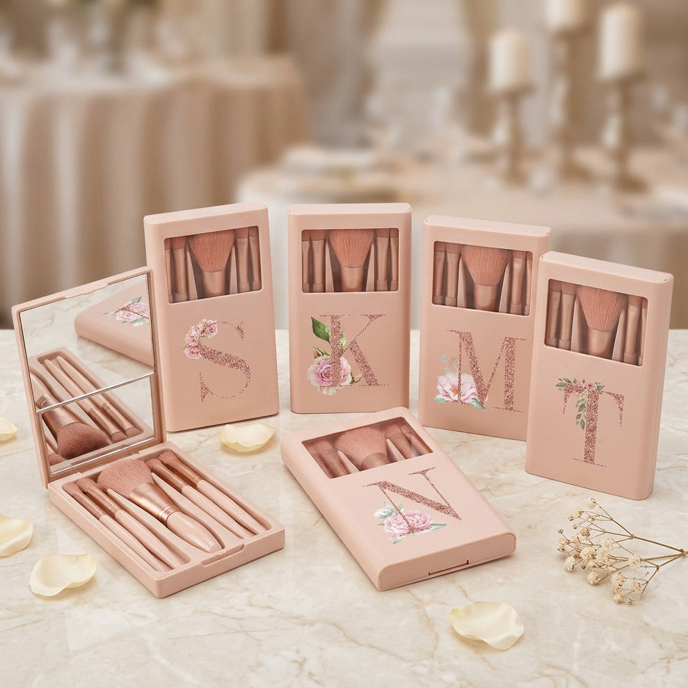 Set of pink make-up brush boxes with floral designs on a marble surface.